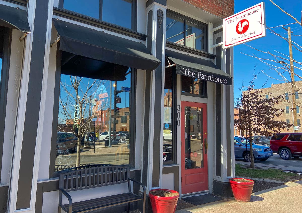 Front of the restaurant, The Farmhouse in the River Market, Kansas City. It features a red door and farmhouse design.